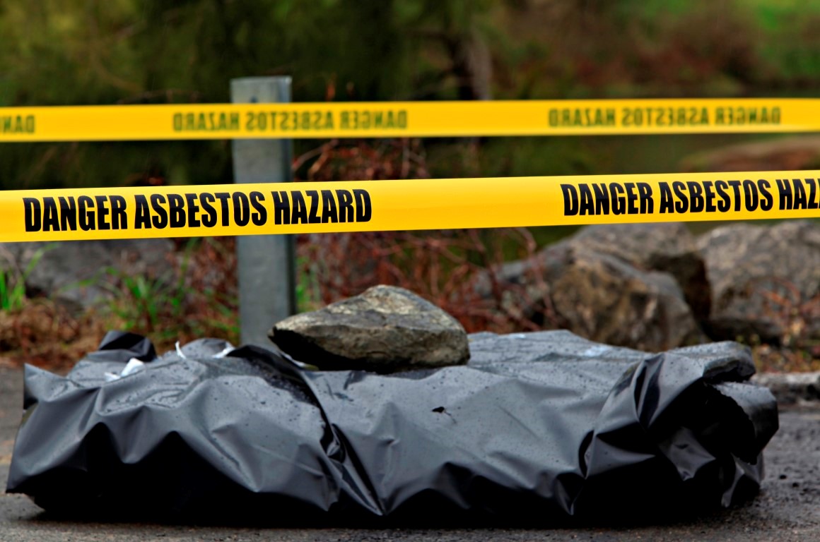 Dumped asbestos wrapped in black plastic in an area marked off with hazard tape