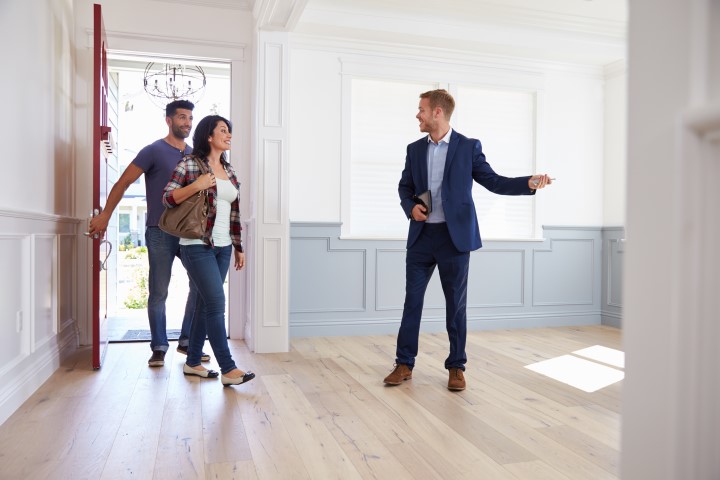 Real estate agent taking couple through a vacant house