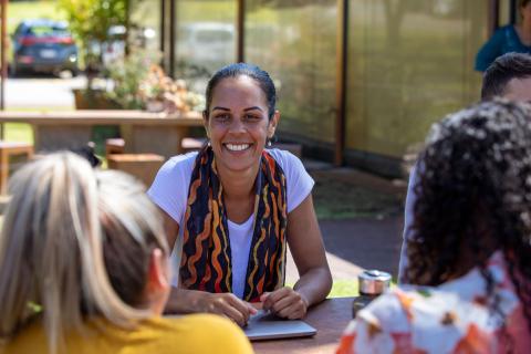 Aboriginal women in western clothes sitting at a table talking and laughing 